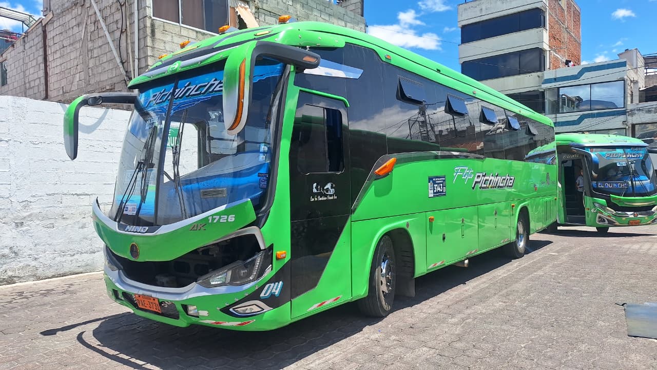 Bus moderno verde de Flota Pichincha estacionado en terminal